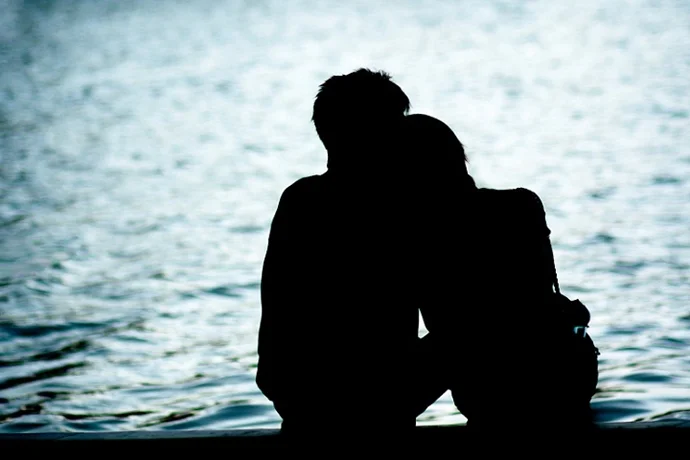 水辺で肩を寄せ合う男女