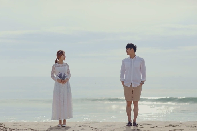 海辺で向かい合う男女