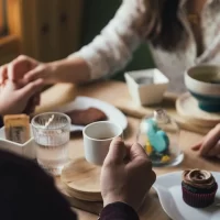 テーブルの上で手を繋ぐ男女の手