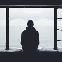 海を見つめる孤独な男性の後ろ姿