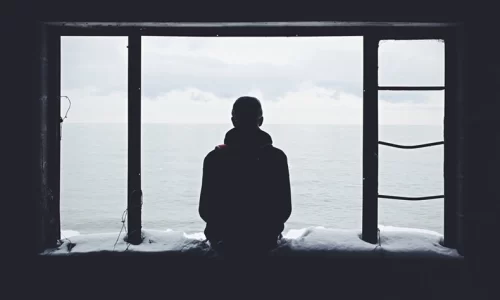 海を見つめる孤独な男性の後ろ姿