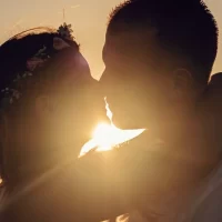 夕日をバックにキスをする男女