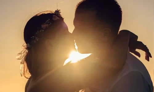 夕日をバックにキスをする男女