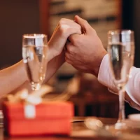 レストランで手を取り合い向かい合う男女