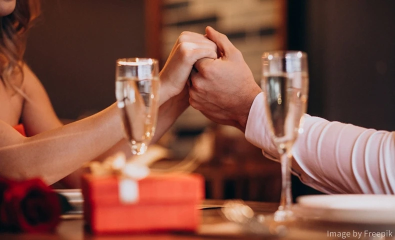 レストランで手を取り合い向かい合う男女